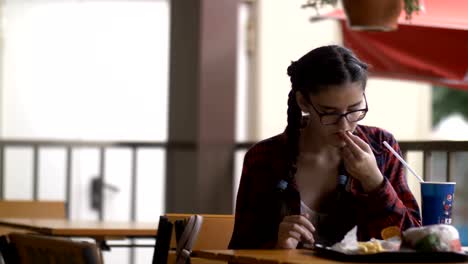 girl-is-sitting-in-a-cafe-watching-information-on-the-internet-and-eating