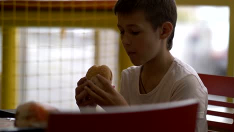 boy-eats-Burger-in-cafe