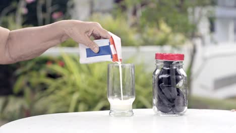 ältere-Frau-Milch-in-Glas-gießen