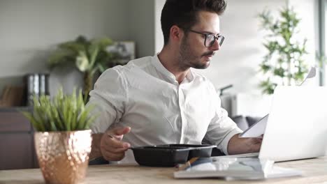 Hombre-de-negocios-ocupado-comiendo-en-casa-oficina