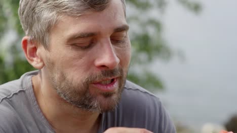 Hombre-disfrutando-la-deliciosa-comida-en-Picnic