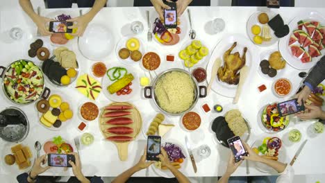 Grupo-de-amigos-con-todas-las-personas-en-la-mesa-en-cena-usa-su-smartphone-para-tomar-fotos-de-la-cena-el-alimento.-Instagram,-concepto-de-adicción-a-la-red-Social.