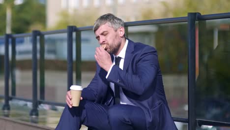 Businessman-eating-pizza-outside