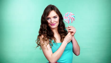 Woman-smiling-girl-with-lollipop-candy-on-green-4K