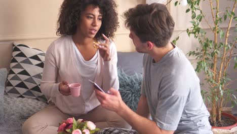 Couple-using-mobile-phone-while-having-breakfast