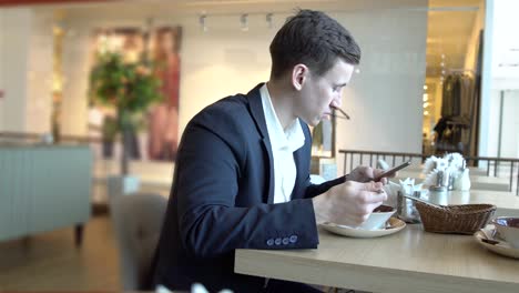 Lunch-break.-Handsome-man-with-a-phone-in-a-cafe