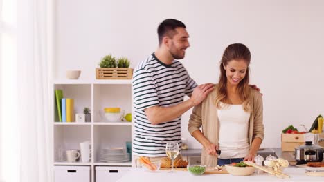 glückliches-Paar-Garen-von-Speisen-in-der-Küche-zu-Hause