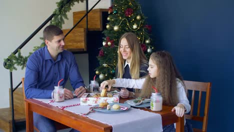 Familia-feliz-comiendo-galletas-de-Navidad-en-vísperas-de-Navidad