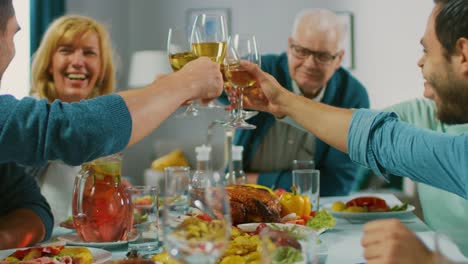 Große-Familie-und-Freunde-feiern-zu-Hause,-vielfältige-Gruppe-von-Menschen-versammelten-sich-am-Tisch.-Essen,-trinken,-Toast-zu-machen-und-Spaß-haben.-Tagsüber-fest.