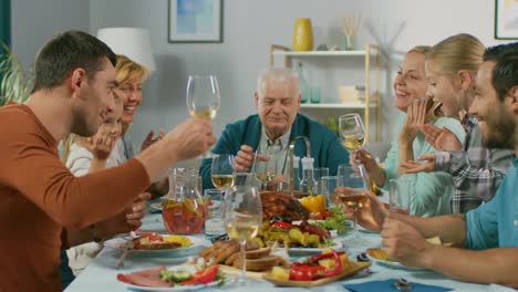 Big-Family-and-Friends-Celebration-at-Home,-Diverse-Group-of-Children,-Young-Adults-and-Old-People-Gathered-at-the-Table-have-Fun-Conversation.-Clinking-Glasses-and-Making-Toast.-In-Slow-Motion.