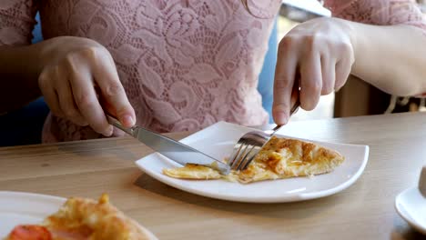 Brünette-Frau-in-einem-Café-ist-eine-leckere-Pizza-essen.