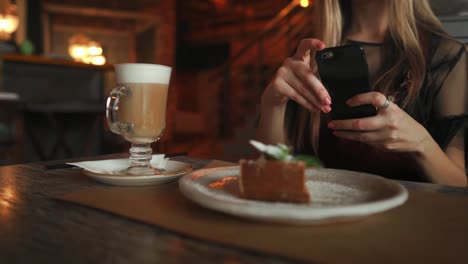 schöne-emotionale-glückliches-Mädchen-macht-Foto-von-Essen-im-Café,-Latte-auf-den-Tisch,-Dessert-Eis-Schokolade-Kuchen-Kirschen-Minze,-Kommunikation-in-sozialen-Netzwerken