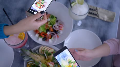 Blogging,-macht-Smartphone-in-Hand-Freundinnen-Foto-von-nützlichen-vegetarische-Essen-während-des-Frühstücks-für-social-Media,-Nahaufnahme