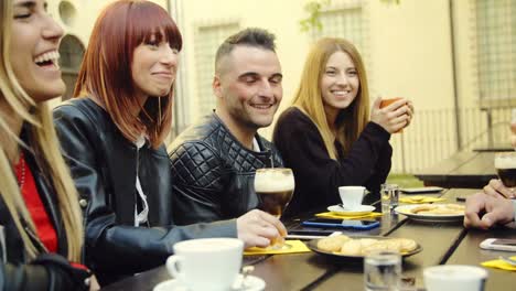 grupo-grande-de-amigos-en-una-cafetería-al-aire-libre