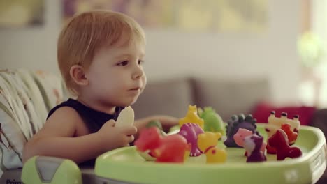 niño-sentado-en-silla-alta-comer-plátano