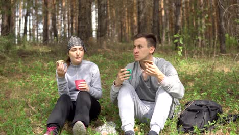 Spaziergang-im-Freien.-Junges-Paar-mit-einem-Snack-im-Wald