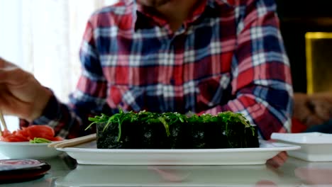 young-man-eating-sushi-in-a-Japanese-restaurant