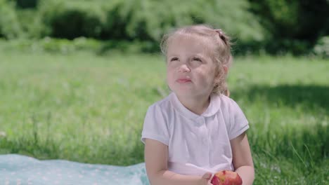 Nutrición-saludable.-Niño-comiendo-jugosa-manzana-al-aire-libre