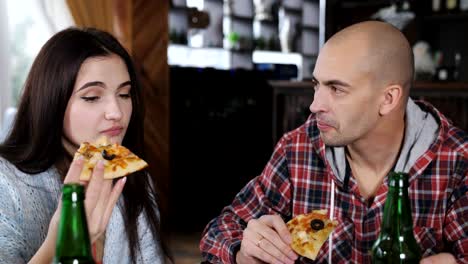 Freunde-im-Restaurant-Pizza-essen-und-reden.