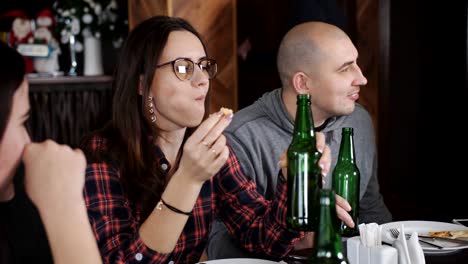 Diversión-en-el-restaurante-comer-pizza-y-beber-cerveza.-Dos-chicos-y-dos-chicas-en-la-pizzería.