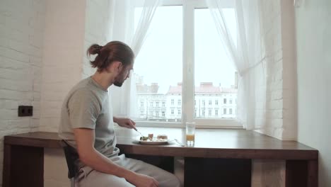 Young-Man-Drinking-Juice-And-Having-Breakfast-At-Home