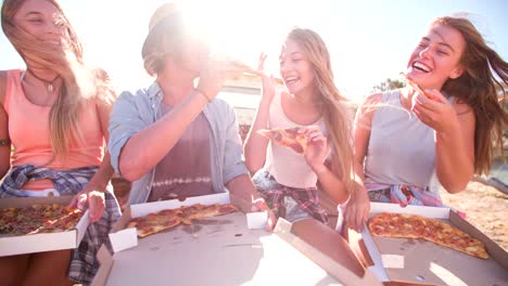 Friends-laughing-and-enjoying-pizza-on-a-summer-day