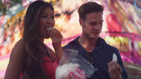 A-couple-eating-cotton-candy-at-a-fair