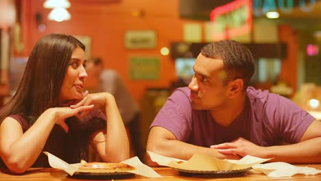 Una-joven-pareja-comiendo-en-un-centro-de-la-ciudad-de-pizzeria