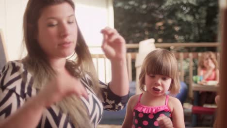 Una-madre-proporciona-su-hija-un-abrazo-mientras-está-comiendo-una-barbacoa-la-cena