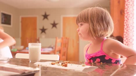 Hermanas-comer-leche-y-galletas-en-la-cocina,-contador