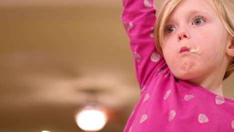 Messy-young-girl-eats-ice-cream-and-her-mom-wipes-off-her-face,-slow-motion