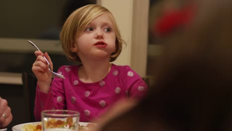 Ein-kleines-Mädchen-essen-Abendessen-mit-ihrer-Familie-hautnah