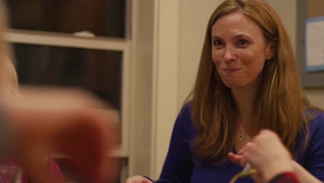 A-mother-eating-dinner-with-her-family,-and-a-little-girl-making-a-disgusted-face-at-salad