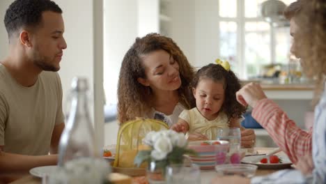 Couple,-young-girl-and-adult-friends-talk-at-kitchen-table