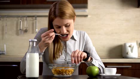 Beautiful-businesswoman-having-breakfast-and-using-her-smart-watch.-Browsing-Internet.-Reading-news