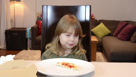 little-child-eating-pizza-and-laughing-at-home