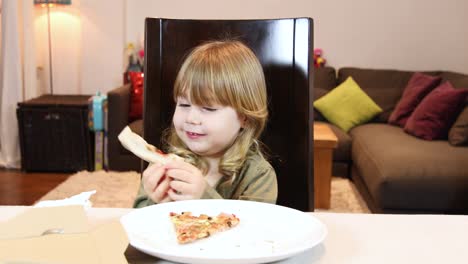 sonriente-niño-comiendo-pizza-en-casa