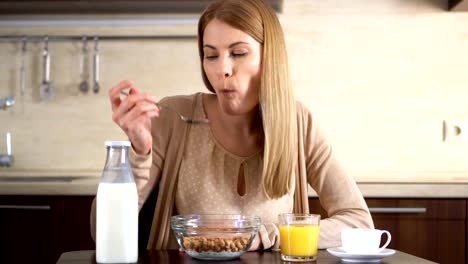 Schöne-junge-attraktive-Frau-Essen-Cornflakes-zum-Frühstück-in-der-Küche.-Tasse-Kaffee