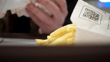 Junge-Frau-isst-Hamburger-und-Pommes-frites