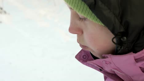 Niña-come-fichas-en-el-bosque-de-invierno