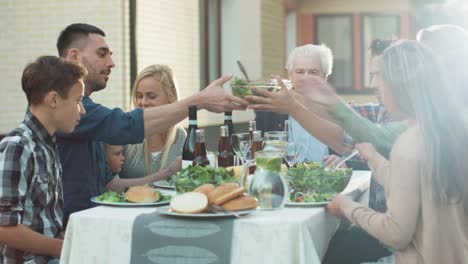 Grupo-de-personas-de-raza-mixta-teniendo-diversión,-comunicación-y-comer-en-la-cena-al-aire-libre-de-la-familia
