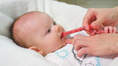 Baby-Girl-is-Taking-Medicine-by-a-syringe