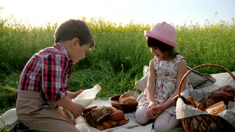 Los-niños-y-la-naturaleza,-amigos-de-césped-verde,-picnic,-niño-y-niña-con-el-alimento-en-la-naturaleza,-los-niños-felices-en-aire-fresco,-el-niño-vierte-leche