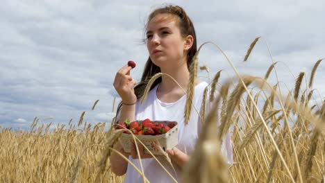 Junges-Mädchen-Köstlichkeiten-in-Erdbeeren-essen