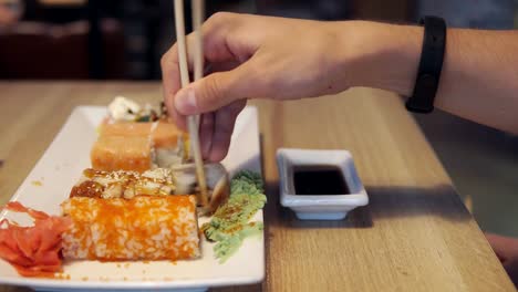 Freunde-Essen-Sushi-und-Dip-in-Soße-in-der-Sushi-bar