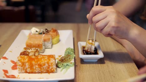 Mädchen-in-Soße-in-der-Sushibar,-Sushi-und-Dip-Essen-Nahaufnahme