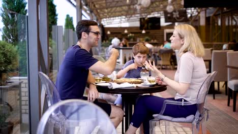 Great-family-is-bonding-in-the-restaurant-together-listening-to-the-father's-stories-and-laughing-loud