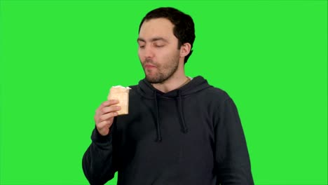 Handsome-young-man-eating-ice-cream-on-a-Green-Screen,-Chroma-Key