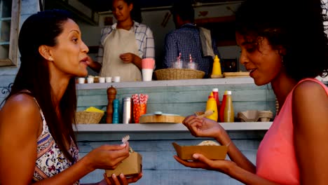 Sonrientes-amigos-comiendo-bocadillos