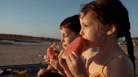 Three-kids-eating-watermelons-at-the-beach